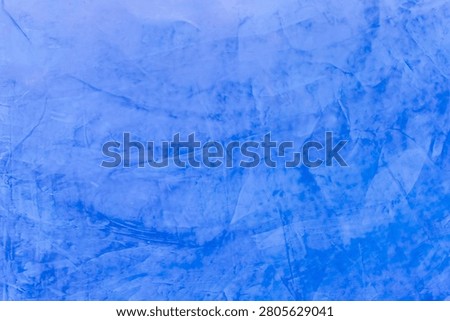 Blue painted plaster wall texture with layered brush patterns subtle tonal variation and artistic finish ideal for backgrounds decorative design and creative projects