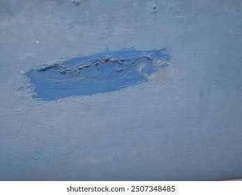 Blue painted wall with patch