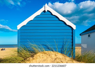 Blue Painted Wooden Beach Hut Seen On A Sandy Beach On A Famous Beach Area In Suffolk, UK.