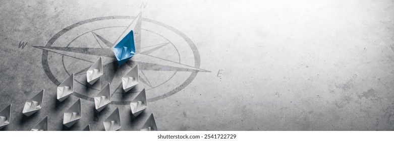 Blue Paper Boat Leading A Fleet Of Small White Boats With Compass Icon On Grey Concrete - Leadership Concept	
