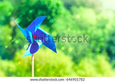 Blue paper weathercock on nature background, sunlight, summertime concept