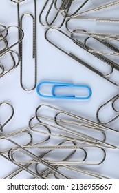 Blue paperclip in the middle of silver paperclip