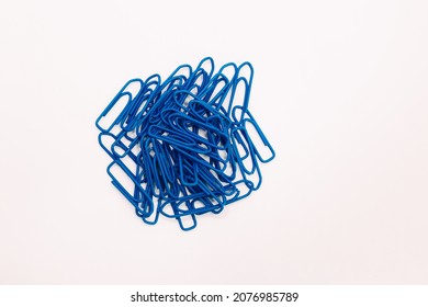 Blue paperclips on white background. Office concept