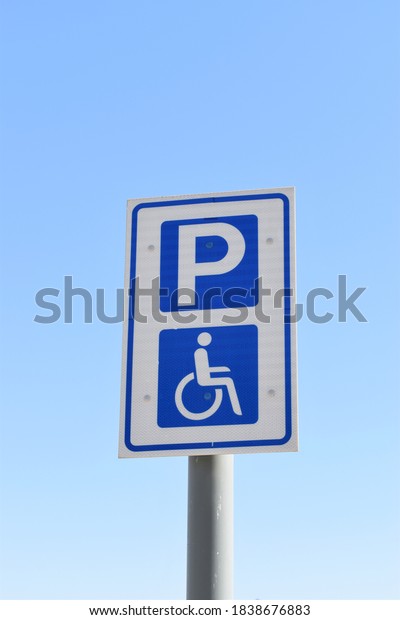 A blue parking sign indicating\
parking for people with disabilities by a wheelchair image\
