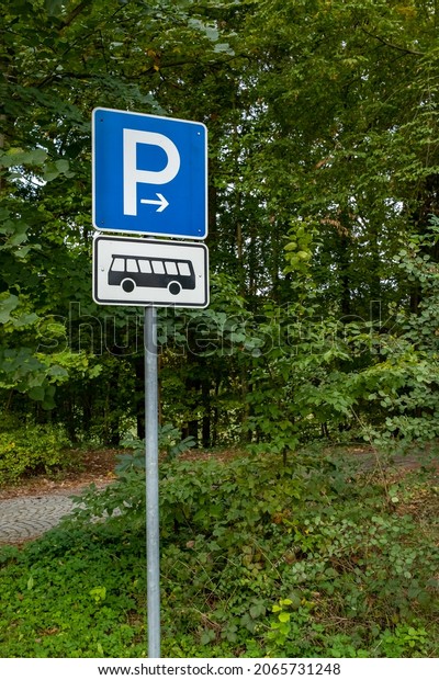 a blue parking sign in a parking lot. Parking lot for\
buses only. 
