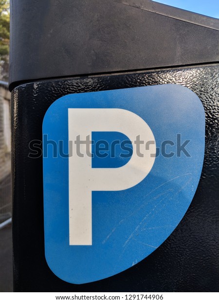 Blue parking\
sign on a pay station in a car\
park