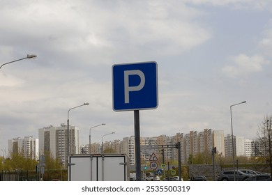 A blue parking sign stands against a backdrop of residential buildings, indicating the availability of parking spaces in the city. A sign permitting parking on city streets. - Powered by Shutterstock