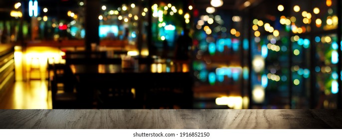 Blue Party Glowing Light And Black Wood Table In Pub Or Bar In Christmas Night Banner Background	