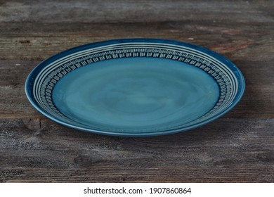 blue pastel beautiful empty plate on dark wooden background. horizontal image. Side view