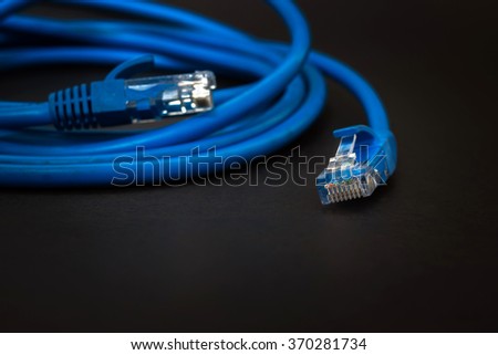 Blue patchcord with RJ45 plug lan network isolated on black background
