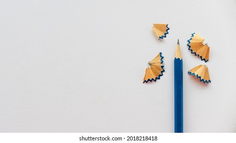 Blue pencil and its shaving on a blank white paper with copy space. - Powered by Shutterstock