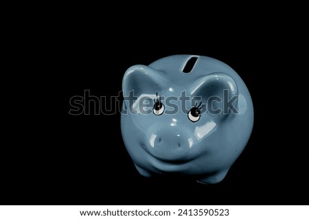 Blue piggy bank or money box isolated on a black studio background