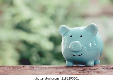 Blue Piggy Bank On Wooden Table And Vintage Bokeh Background. Concept Of Storage, Accumulation. Crisis, Inflation, Financial Collapse, Save Money Business Copy Space.