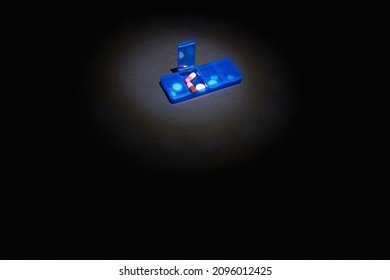 Blue Pill Box With Pills On Black Background