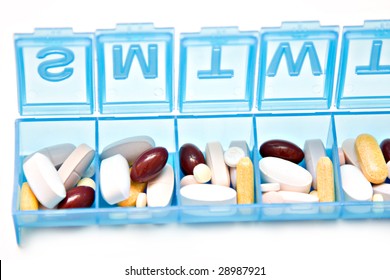 A Blue Pill Box With A Week's Worth Of Vitamins And Prescriptions.