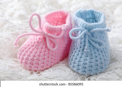 Blue And Pink Baby Booties On White Background