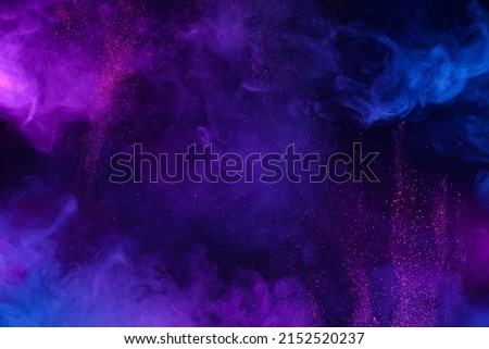 Blue and pink colorful clouds of smoke and shiny glitter powder particles bursts abstract background