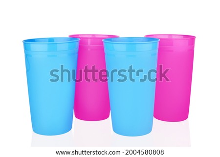Blue pink empty plastic cups white background isolated close up, four disposable blank drinking glasses, party beverage, cocktail, water, coffee mug, tea, fruit juice, tumbler design, picnic utensil