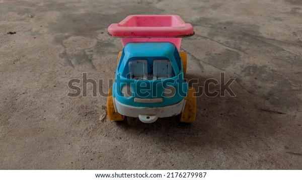 Blue and pink toy truck\
on the floor