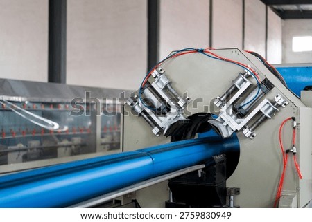 Blue pipe processing equipment on water-resistant production line in industrial factory