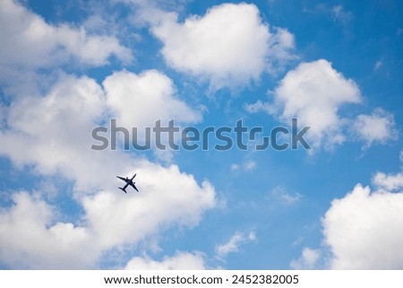 a blue plane in a blue cloudy sky