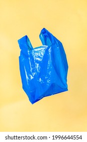 Blue Plastic Bag Floating With A Yellow Wall