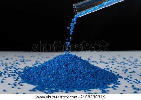 Blue plastic beads on wood  background, Polymers bead or polymer resin, polymer pallet, Product from petrochemical plants. granules polymer, Concept roof of house is made of polymer plastic. [[stock_photo]] © 