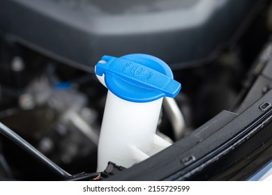 A blue plastic bottle cap of car windshield washer water storage tank. Vehicle equipment and object part photo. Selective focus.