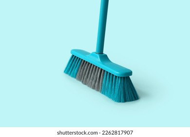 Blue plastic broom on color background - Powered by Shutterstock