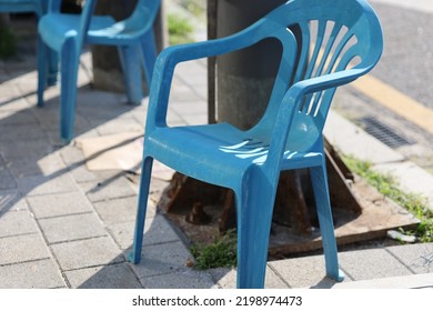 A Blue Plastic Chair On The Road