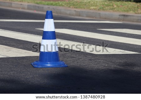 Blue plastic Cone on the crosswalk on the asphalt road. Road Safety concept. Selective focus-