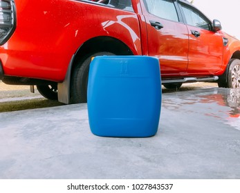 Blue plastic container on the ground with car background. - Shutterstock ID 1027843537