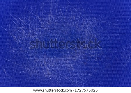 Blue, plastic, grained cutting board with a lot of scratches.