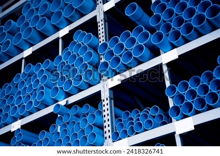 Blue plastic pipes in a stack in a large warehouse of a shopping center
