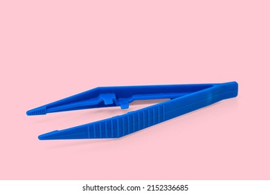 Blue Plastic Sterile Surgical Tweezers Isolated On Pink Background.