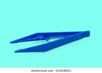 Blue Plastic Sterile Surgical Tweezers Isolated On Aque Background.