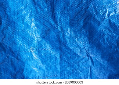 Blue plastic waterproof tarpaulin, textured background, polyethylene sheet.