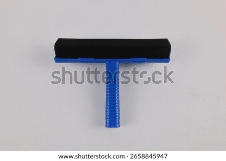 Blue plastic window squeegee with sponge and rubber blade, isolated on white background. Dual-purpose cleaning tool for removing water and wiping surfaces such as glass, mirrors, or car windshields