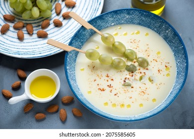 Blue plate with ajoblanco or spanish traditional cold soup over grey concrete background, elevated view, horizontal shot