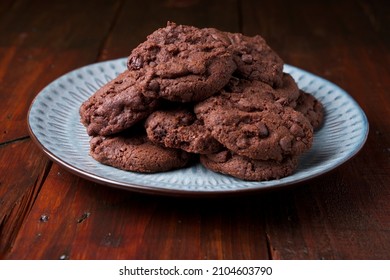 Blue plate with homemade triple chocolate chip cookies on a wood surface - Powered by Shutterstock