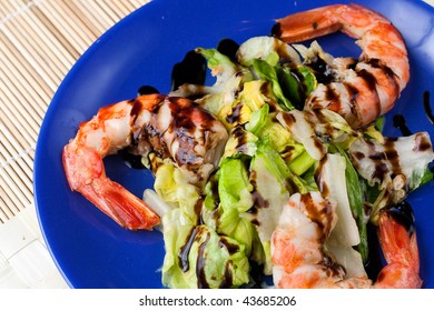 A Blue Plate With A Salad Of Grilled Argentinian Prawns With Balsamic Vinegar Glaze