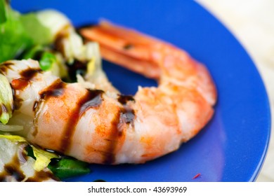 A Blue Plate With A Salad Of Grilled Argentinian Prawns With Balsamic Vinegar Glaze