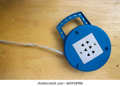 Blue plug on a wooden table - Shutterstock ID 465918986