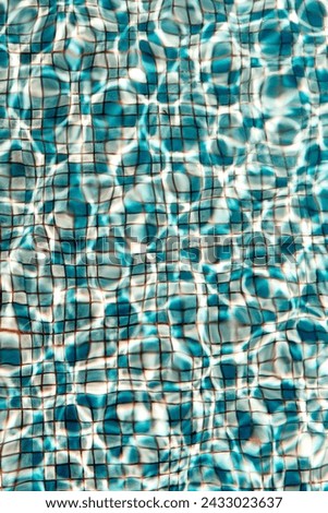 blue pool tiling with wavelets and light reflection