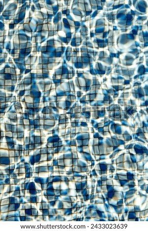 blue pool tiling with wavelets and light reflection