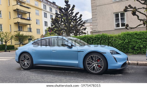 Blue Porsche Taycan\
electric sports car parked on a urban street in Frogner, Oslo,\
Norway - May 16, 2021