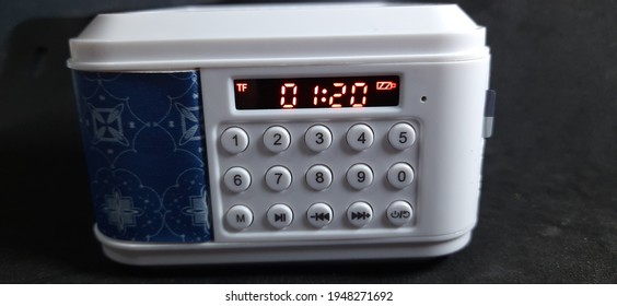 A blue portable speaker with batik pattern isolated on black background.wireless speaker