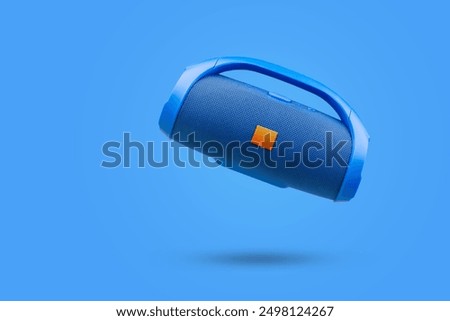 Blue portable wireless Bluetooth speaker, on a blue background. Device for playing music.