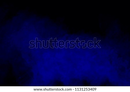 Blue powder explosion on black background. Freeze motion of colo