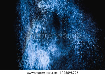 Blue powder explosion on black background. Colored cloud. Colorful dust explode. Paint Holi.
